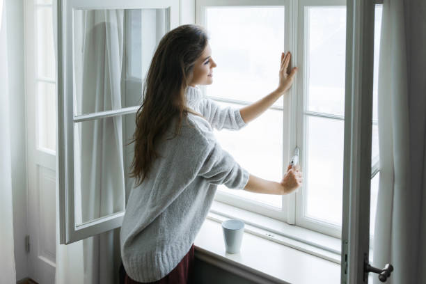woman opening window for better ventilation