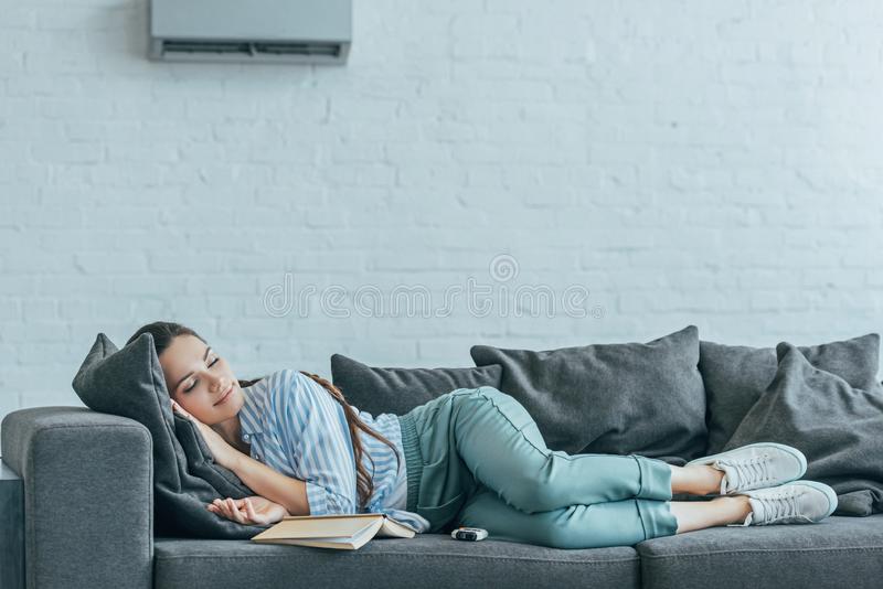 woman sleeping on a sofa comfortably after selecting best air conditioner temperature for sleeping