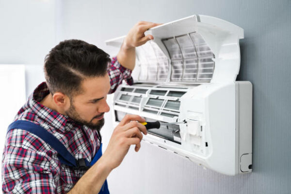 Technician doing Air Conditioner repair brighton