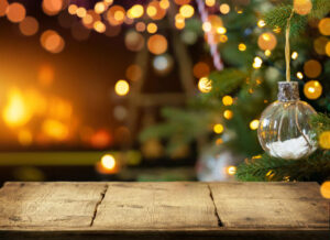 Empty wooden table on Christmas ornaments background with fireplace.