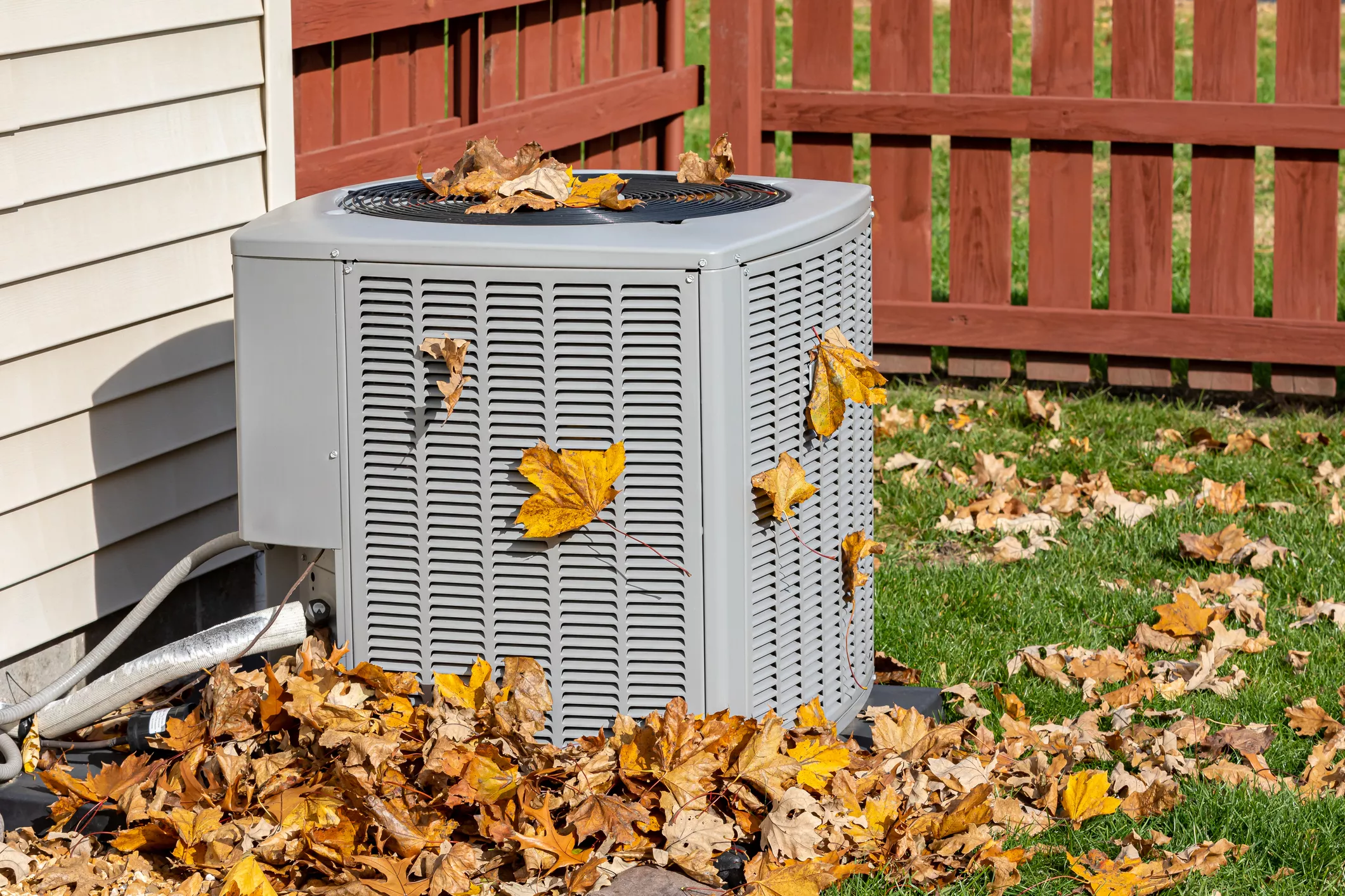 Autumn leaves on an air conditioner. Depicting impact of leaves on HVAC