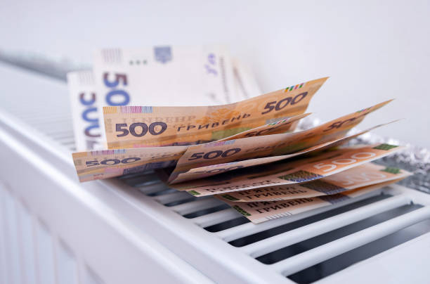 cash on heating radiator at home. Rise in the price of home heating, hot water, natural gas, symbolic image.