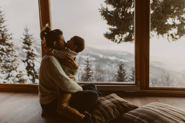 Photo of young mother bonding with her son in a log cabin during winter holidays after getting tips on how to improve indoor air quality in winter