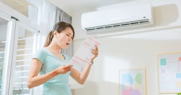 woman stressed after looking at the bills of hvac solutions heating and cooling systems