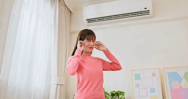woman disturbed because of air conditioner noise
