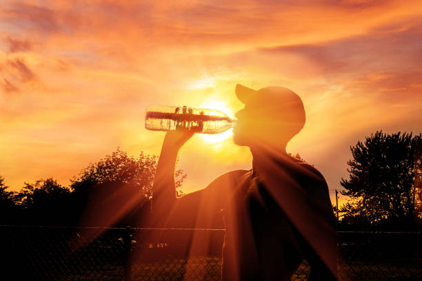Silhouette of a man drinking water during australia heatwave weather warning