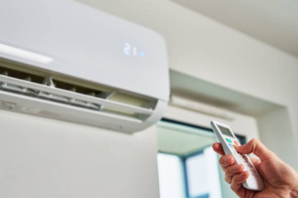 Hand adjusting temperature on air conditioner with remote control, Working air conditioner for comfort temperature in home at hot summer understanding what is the dry mode on an air conditioner